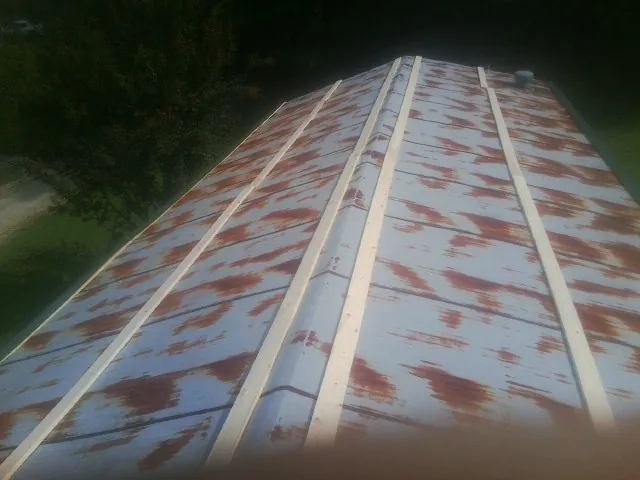 Rusted metal roof panels with new wood purlins before replacement — Storm Damage Roof Repair in Baden by Roofing Brothers