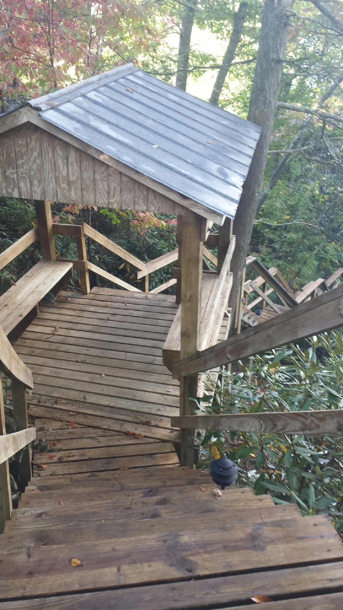 Metal roofed shelter over wooden steps on a wooded walkway — Skylight Repair & Installation work by our crew in Baden