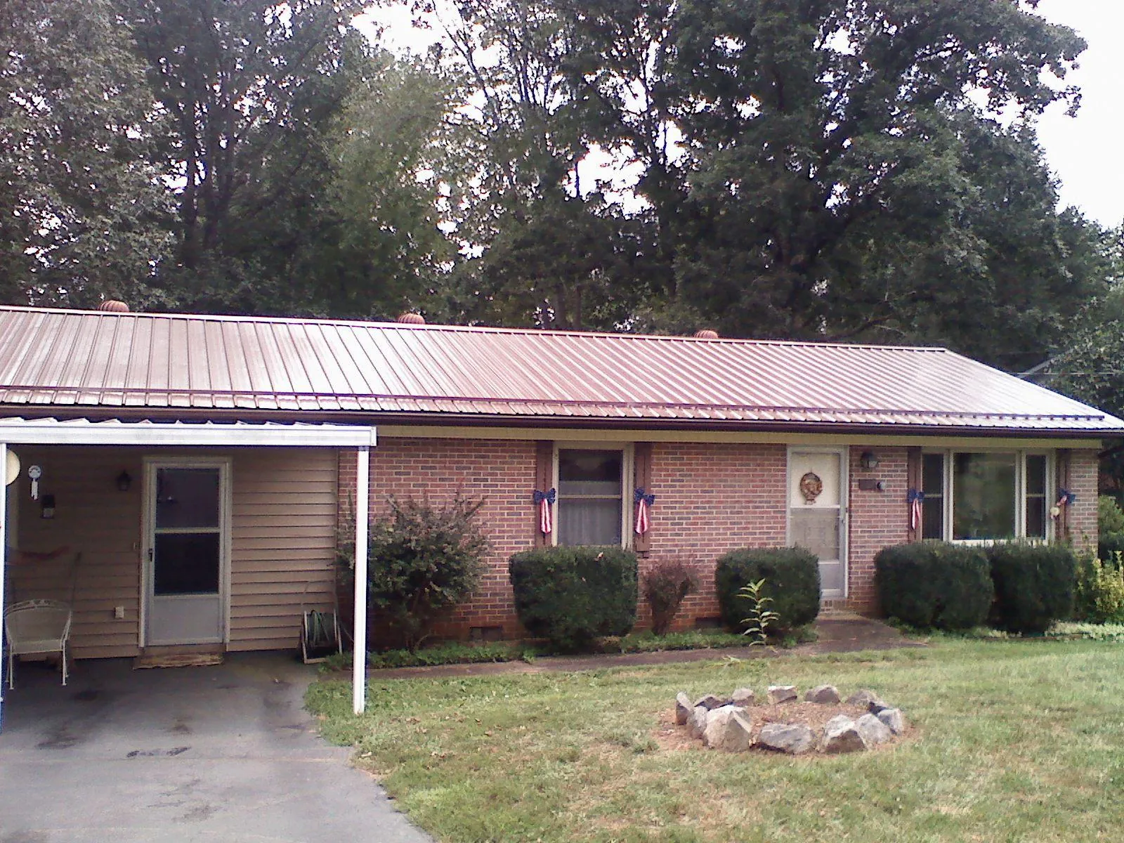 Bronze metal roof and carport on a brick ranch home — Roof Repair work by our crew in Baden